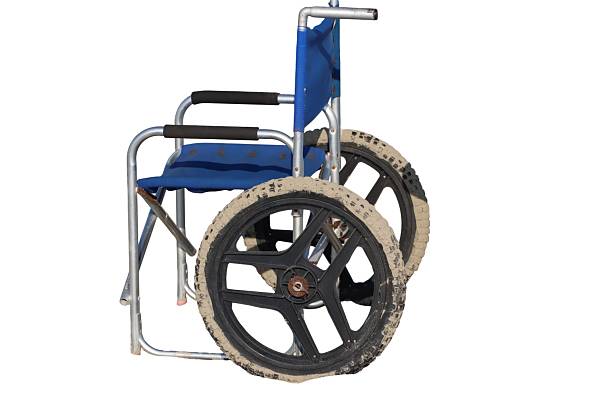 Paraplegic handicapped man in wheelchair by the lake. He is exercising with weights.