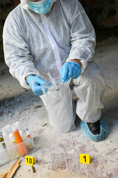 istock Middle-Aged Investigator Surrounded By Forensic Tools And Markers 2230601655