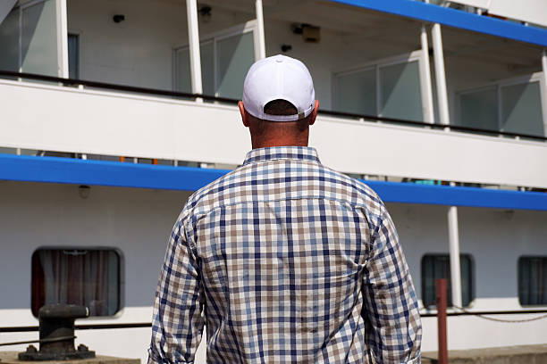 Tourist wearing a white cap looking at a cruise ship before embarking for a holiday trip