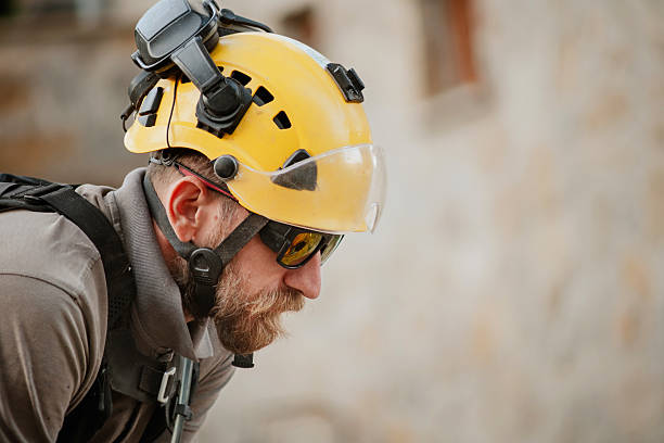 Worker Wearing Yellow Safety Helmet and Protective Gear Outdoors stock photo