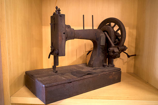 A vintage sewing machine with rustic appearance on the shelf with wooden background.