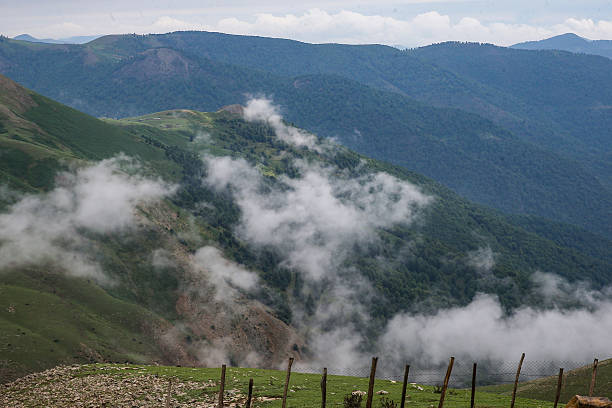 Atmospheric scene of shepherd huts in the highlands of Masal, northern Iran, surrounded by rolling mist and dense forests — a dreamy landscape of rural life and untouched nature.