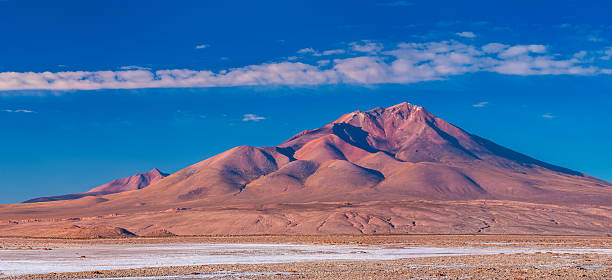 The Altiplano (Spanish for high plain), in west-central South America, where the Andes are at their widest, is the most extensive area of high plateau on earth outside of Tibet. Lake Titicaca is its best known geographical feature. The Altiplano is an area of inland drainage (endorheism) lying in the central Andes, occupying parts of Northern Chile and Argentina, Western Bolivia and Southern Peru. Its height averages about 3,750 meters (12,300 feet), slightly less than that of Tibet. Unlike the Tibetan Plateau, however, the Altiplano is dominated by massive active volcanoes of the Central Volcanic Zone to the west like Ampato (6288 m), Tutupaca (5816 m), Nevado Sajama (6542 m), Parinacota (6348 m), Guallatiri (6071 m), Cerro Paroma (5728 m), Cerro Uturuncu (6008 m) and Licancabur (5916 m), and the Cordillera Real in the north east with Illampu (6368 m), Huayna Potosi (6088 m), Ancohuma (6427 m) and Illimani (6438 m). The Atacama Desert, one of the driest areas on the whole planet, lies to the southwest of the Altiplano. In contrast, to the east lies the humid Amazon Rainforest.