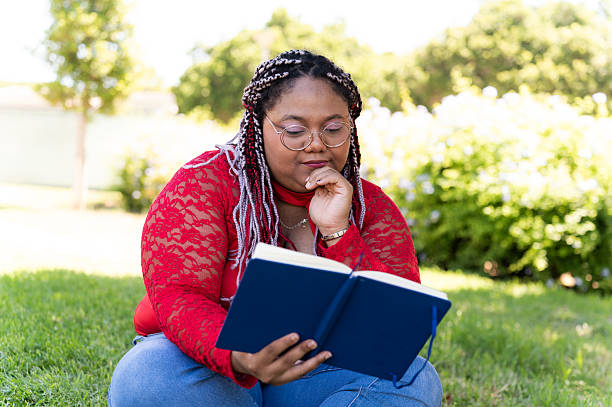 istock Woman reading a book in the park 2230619740