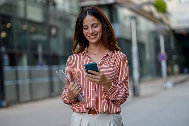 istock Professional woman working remotely, navigating urban street with mobile devices 2230627782