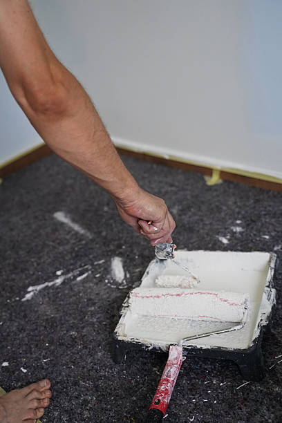 istock Middle-Aged man painting walls with roller during the home renovation 2230628677
