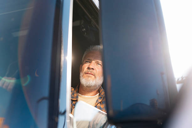 istock Senior truck driver looking out the window enjoying sunlight 2230629843