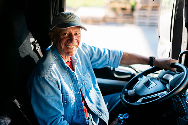 istock Senior truck driver smiling and holding steering wheel 2230629862