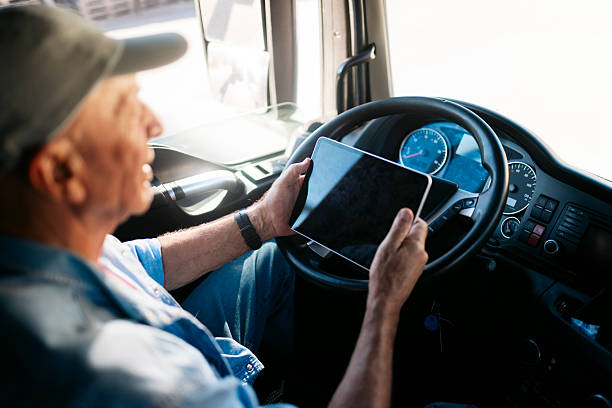istock Truck driver using digital tablet while driving modern truck 2230629884