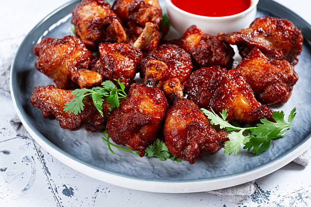 istock Crispy pieces of fried chicken, on a plate with sauce and herbs, in a modern kitchen environment, there are no people 2230630467
