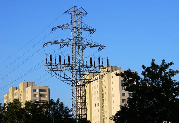 The view of a tall electric pole between the residential high rise buildings