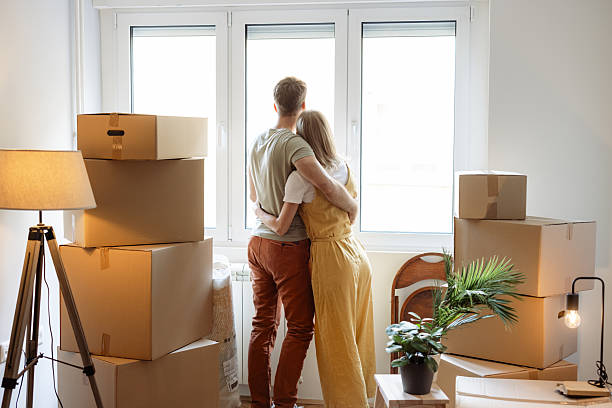 istock Couple embracing in their new home surrounded by moving boxes 2230633220