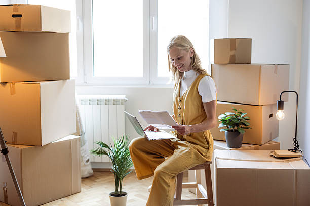 istock Woman holding a document while surrounded by packed boxes in her new home 2230633248