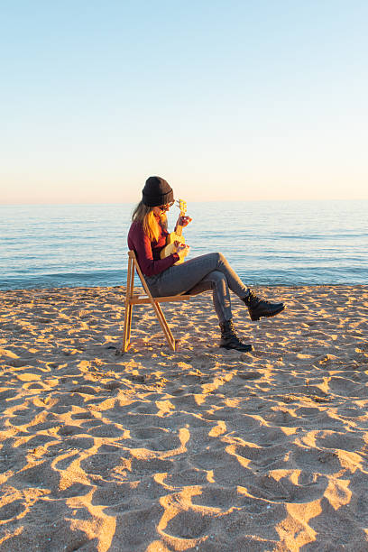 Young men playing acoustic guitar on the beach. Happy man person playing acoustic guitar music instrument seaside sitting on sand tropical beach island. Asian musician Happy guitarist hobby lifestyle