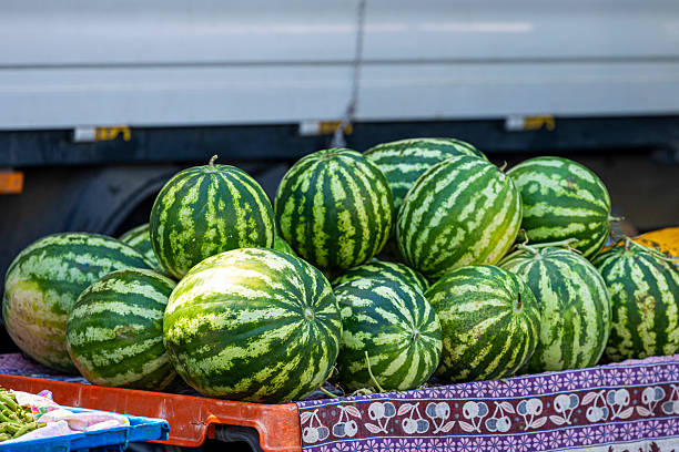 Rio de Janeiro, Brazil - March 7, 2003: Vendors work behind stand selling watermelon at outdoor fruit and vegetable market in Ipanema. Due to high prices and limited local demand, more than 70 percent of the country's organic production is exported. 