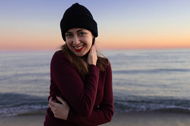istock Young woman smiling at the beach at twilight 2230634152