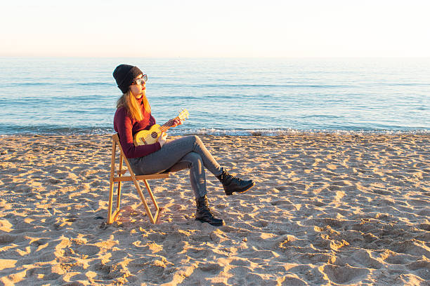 istock Musician playing ukulele on the beach at sunset 2230634779
