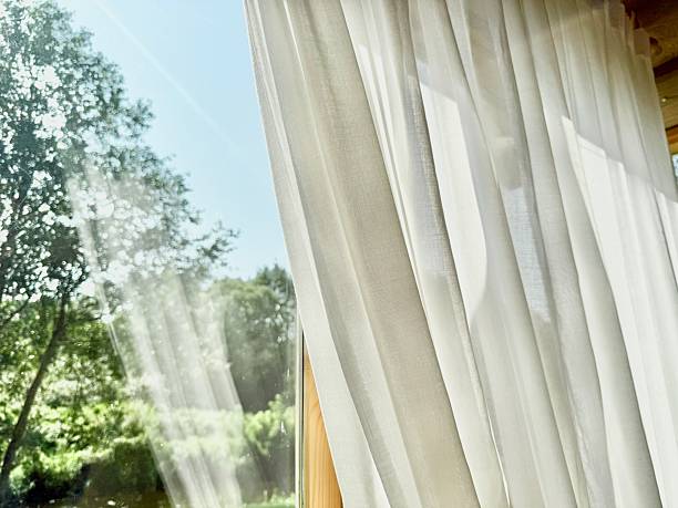 istock Natural Light Through White Linen Curtains on Wooden Window Background 2230634964