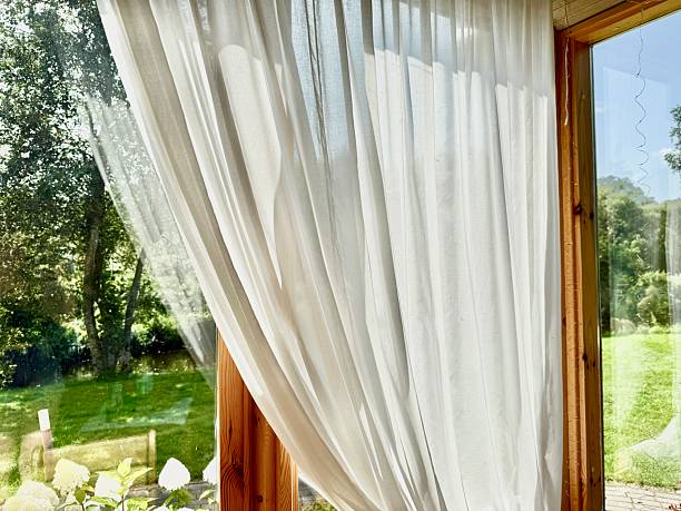 istock Natural Light Through White Linen Curtains on Wooden Window Background 2230637185
