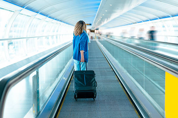 istock Traveling through a modern airport walkway while pulling a suitcase on a busy day in an airy terminal 2230640169