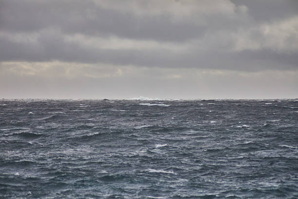 Vast ocean waves ripple under a cloudy sky, evoking a dramatic and moody seascape. Dark hues and weathered waters emphasize the raw power and beauty of nature. Perfect for serene or intense themes.