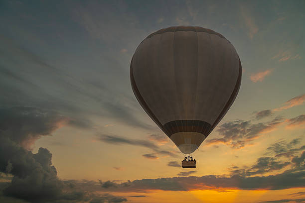 Colorful hot air balloon flying at sunset.