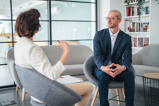 istock Collaborative discussion in a modern office. Happy businessman smiling while discussing sales with his colleague. 2230659874