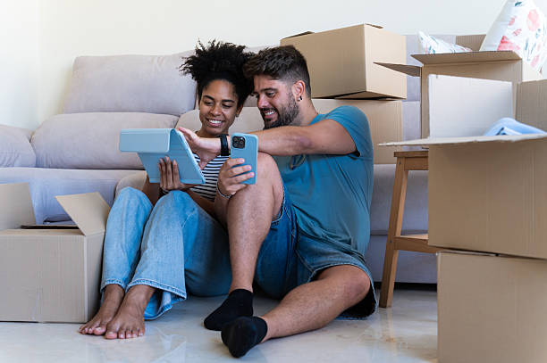 istock Couple organizing new home using tablet and smartphone 2230665954