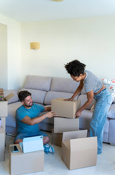 istock Young couple unpacking cardboard boxes in new apartment 2230666416