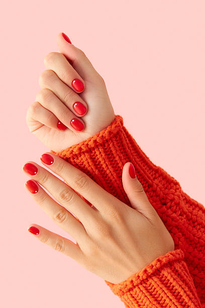 istock Womans hands with red manicure on pink background. Minimalist nail design 2230667978