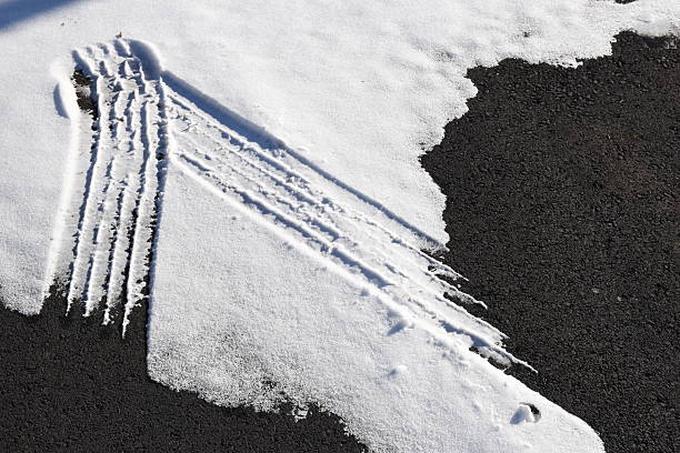Tracks of car tires in thin layer of first snow