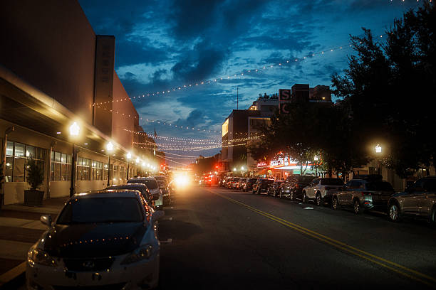 String lights and storefronts illuminate a busy downtown street in Savannah, Georgia on a summer evening.