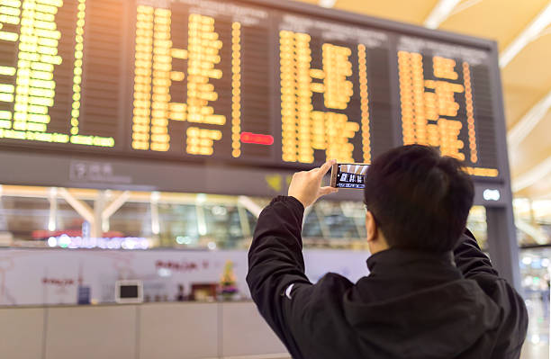 istock Passenger looking at departures board in airport terminal. 2230677774