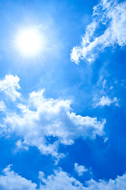 A radiant summer sun shines brilliantly in a deep blue sky, casting warm light over fluffy white clouds. The image conveys freshness, optimism, and the boundless energy of a sunny day.