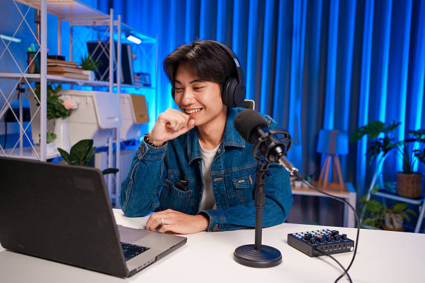 istock Smiling podcast host looking at laptop screen 2230686472
