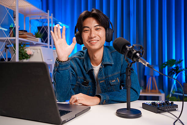 istock Podcast host waving to audience during live show 2230686473