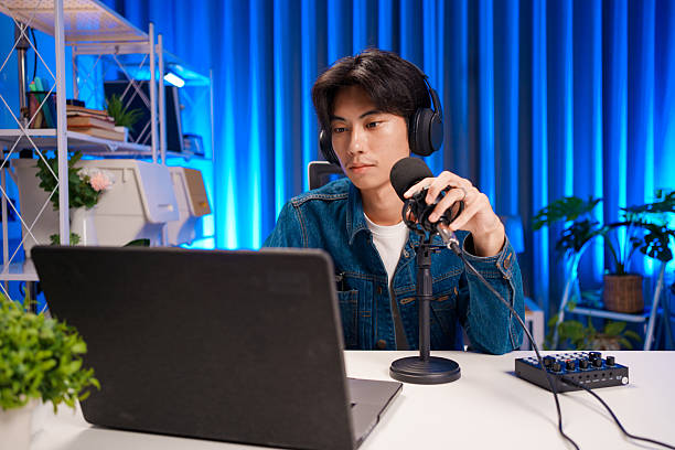 istock Young man working on podcast production with microphone and laptop in studio 2230686474