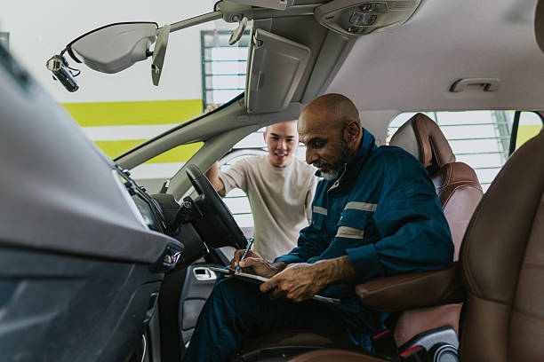 Asian car mechanic diagnosing and inspecting a car for customers