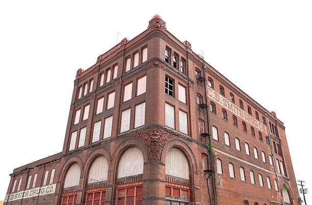 A large building with a corner that is cut off. The building is made of brick and has a lot of windows