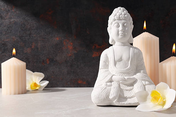 istock Buddha statue, candles and flowers on dark background, space for text 2230692603