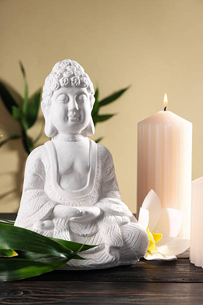 istock Buddha statue, bamboo, candles and flower on beige background 2230692917