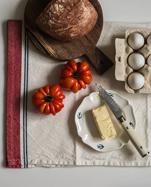 Breakfast ingredients - eggs, butter, fresh bread on the table, top view