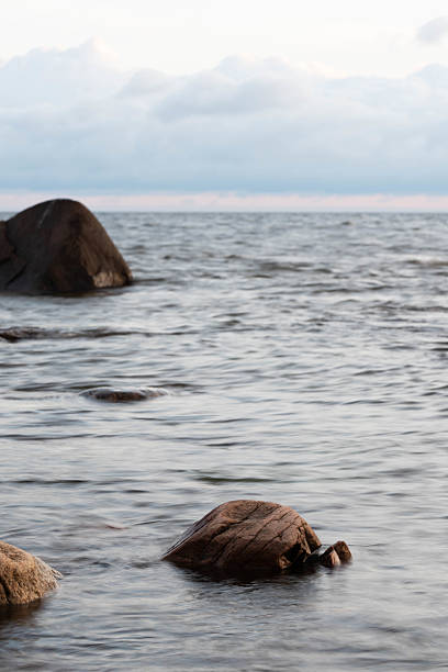 Minimalist seascape with stones emerging from the water, symbolizing resilience, balance, and natural beauty.