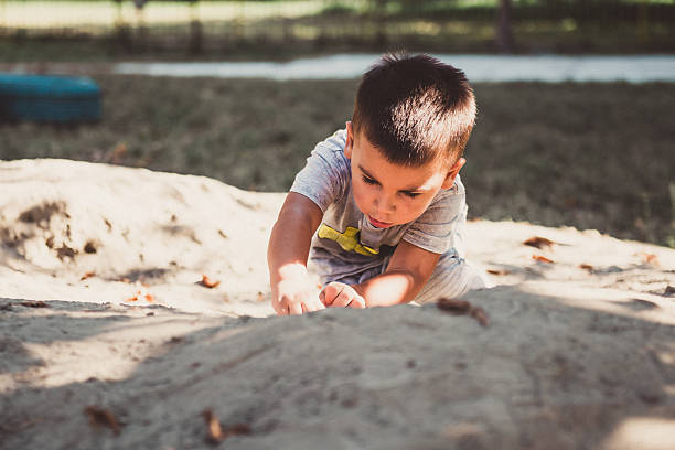 istock Toddler boy playing with sand on a sunny day 2230713901