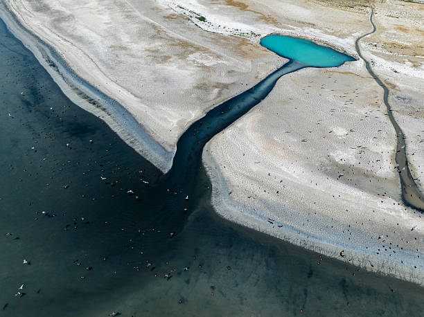 istock NATURAL GROUNDWATER SOURCECracked dry soil and shrinking lakes. PATTERNS emerging in nature, abstract shapes, drought and climate crisis, water scarcity, global warming, and drying soils.global climate crisis,top-down photography with droneabstract 2230714129