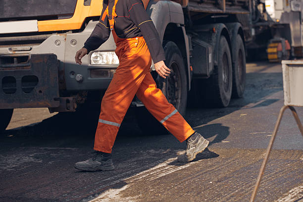 istock Construction worker working on a new asphalt layer on a public street. 2230715041