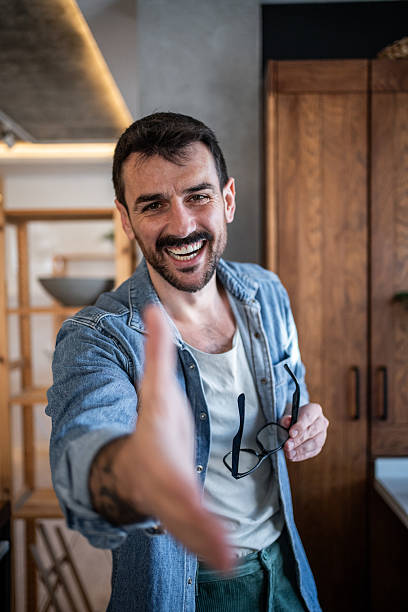 istock Smiling man offering handshake in modern apartment 2230722894