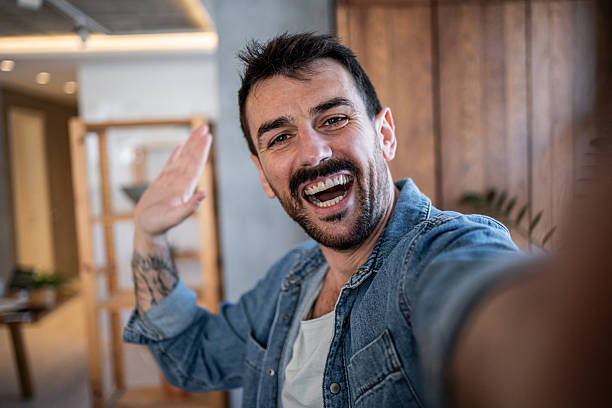 istock Happy man taking a selfie and waving at home 2230722907