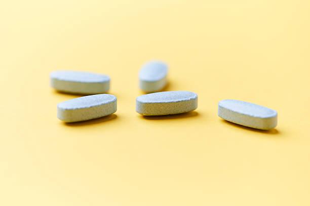 istock Multivitamin tablets on bright paper background. Close up. Copy space. 2230723425