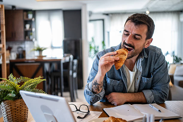 istock Freelancer enjoying a croissant during his work from home morning routine 2230723939